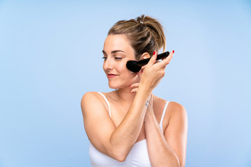 Young blonde woman with makeup brush