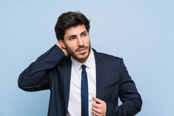 Businessman over isolated blue wall thinking an idea