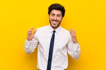 Businessman on isolated yellow background laughing
