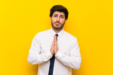 Businessman on isolated yellow background pleading