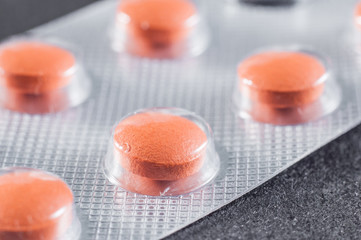 Bright orange pills in sticks, close-up