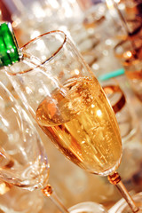 Champagne is poured into a glass goblet on the festive table close-up