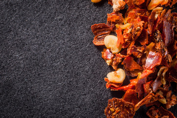 Pounded red chilli pepper with seeds on a dark background close-up