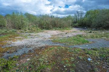 Fototapeta premium Site of former gas works, now derelict and overgrown after many years of disuse.