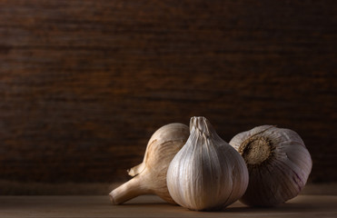 group of garlic head on wooden background , low light.