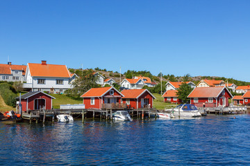 Fototapeta na wymiar Boats at the pier with boat house on the Swedish coast