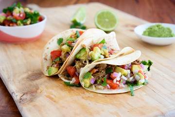 Pulled pork tacos with salsa, guacamole and lime in background, with copy space - obrazy, fototapety, plakaty