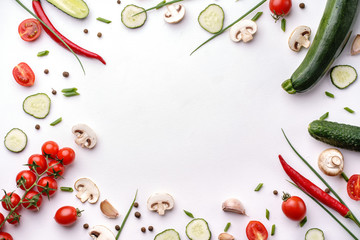 Fototapeta na wymiar Healthy food composition. Frame made of cherry tomatoes, champignons, cucumber, basil leaves, garlic, chilly pepper on white background. Diet, cooking, culinary concept. Flat lay, top view, copy space