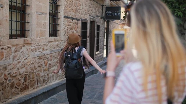 Travel tourists friends laughing taking photo with smartphone. Women girlfriends traveling in Europe smiling joyful having fun.