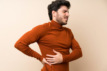 Handsome over isolated wall suffering from backache for having made an effort