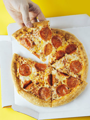 Pizza in a box on a yellow background