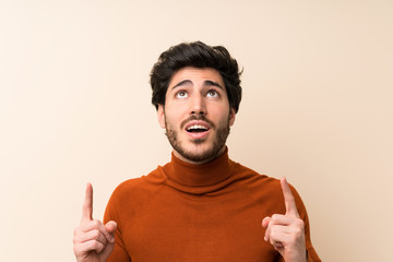 Handsome over isolated wall pointing with the index finger a great idea