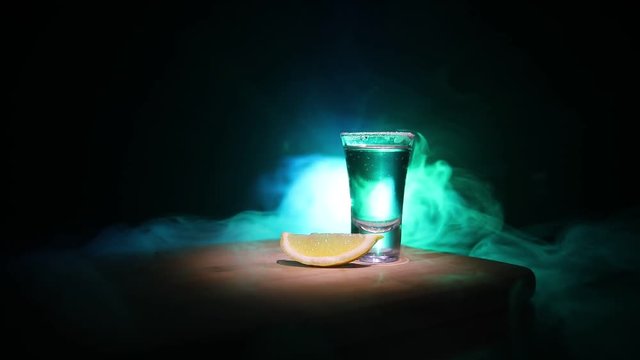Club drink concept. Tasty alcohol drink cocktail tequila with lime and salt on vibrant dark background or glasses with tequila at a bar. Selective focus