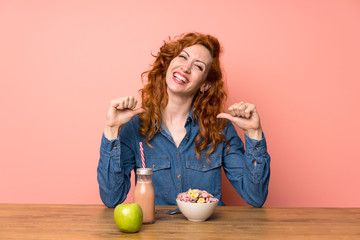 Redhead woman having breakfast cereals and fruit proud and self-satisfied