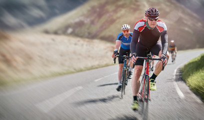 Fototapeta na wymiar Cyclists out racing along country lanes in the mountains in the United Kingdom.