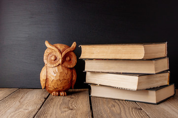 Back to school, the concept of parenting. A stack of books and a statuette of an owl. A day of...