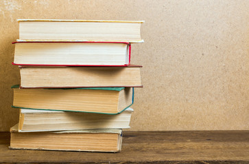 old books stacked on a wooden shelf