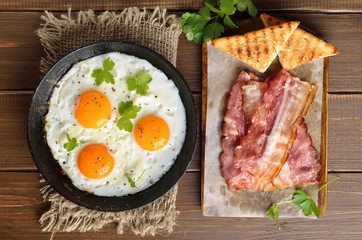 Fried eggs, bacon and toasts