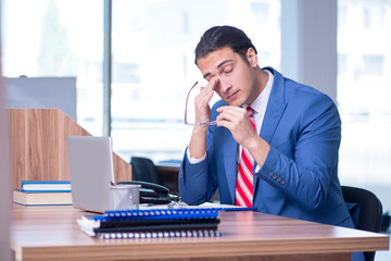 Young handsome businessman sitting in the office 