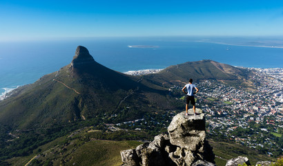 A hiker looking out over Cape Town from the top of Table Mountain - obrazy, fototapety, plakaty