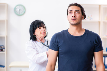 Young male patient visiting aged female doctor 