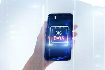 Woman Hand holding mobile phone. Server room background. Inscription on a virtual screen: Big Data. Double exposure.