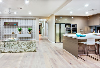 Closeup of a modern kitchen and living room withh lights on