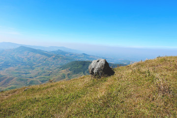 Rock on hill with mountain and blue sky background / Landscape stone field