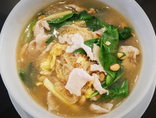 Rice vermicelli noodle with pork corn and chinese Kale vegetable soaked in gravy in bowl dark