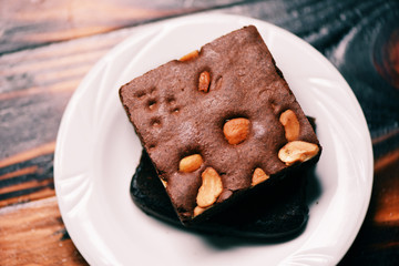 brownies cake on the table / chocolate cake slice with nut in the plate on wooden
