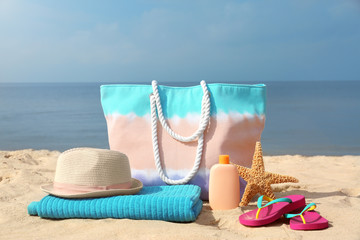 Obraz na płótnie Canvas Set of different stylish beach accessories on sand