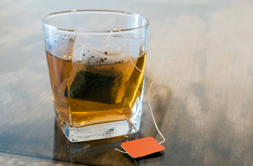 Tea bags in clear glass and hot water