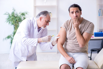 Obraz premium Male patient visitng doctor for shot inoculation 
