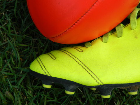 Close up of  a football and football boot on a grass background