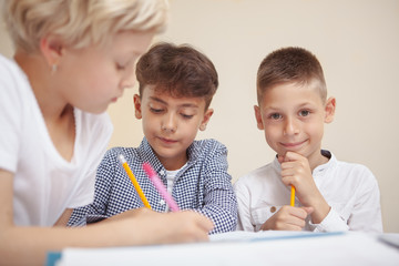 Children development, intelligence concept. Adorable little boy smiling to the camera, sitting with...