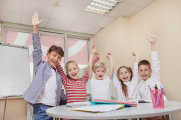 Happiness, childhood, friendship concept. Group of little elementary schoolkids schreaming...