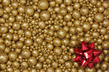 Christmas background with big and small golden glitter balls and big red ribbon star