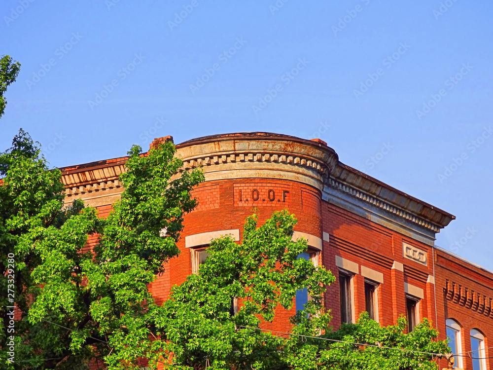 Wall mural Upward view I.O.O.F. building historic downtown Sapulpa Oklahoma Route 66. Brick architecture and blue sky background. Small town USA.