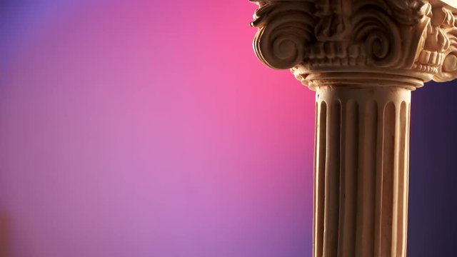 Single ancient corinthian column rotating slowly on color background