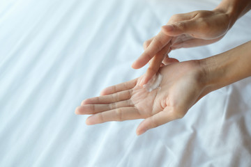 Fototapeta premium Woman applying moisturizing cream/lotion on hands, beauty concept.