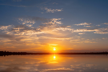 Fototapeta na wymiar Sunset reflection lagoon. beautiful sunset behind the clouds and blue sky above the over lagoon landscape background. dramatic sky with cloud at sunset