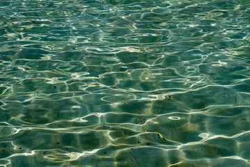 Light games created by the sun in the waters of a shallow pool