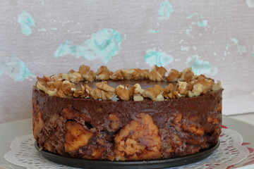 Cake without baking cookies and chocolate. Decorated with walnut crumbs. On a shabby aged background.