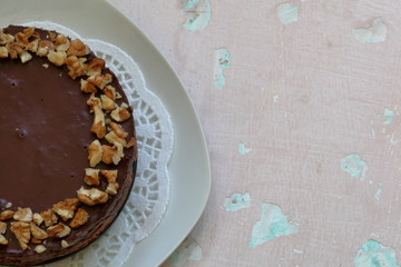 Cake without baking cookies and chocolate. Decorated with walnut crumbs. On a shabby aged background.