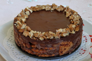 Cake without baking cookies and chocolate. Decorated with walnut crumbs. On a shabby aged background.