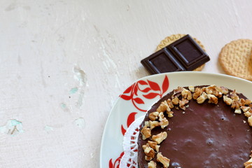 Cake without baking cookies and chocolate. Decorated with walnut crumbs. On a shabby aged background.
