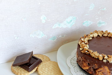 Cake without baking cookies and chocolate. Decorated with walnut crumbs. On a shabby aged background.