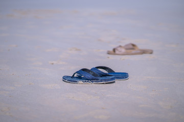 Flip flops on a sandy ocean beach