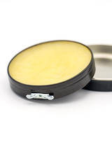 Colorless transparent wax for shoes. Open round container on a white background Shoe care concept