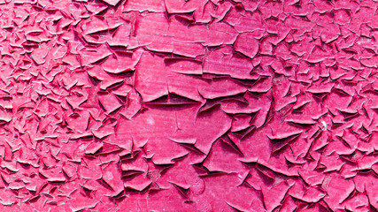 Concrete wall with cracked red paint as abstract background